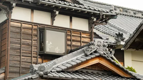 瓦屋根と板張りの外壁が残る古い木造住宅